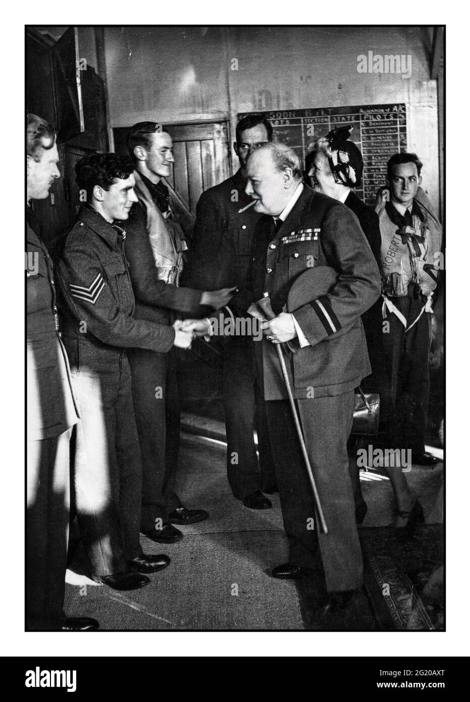 Morale boosting visit during the Battle of Britain by British Prime Minister Winston Churchill wearing the uniform of Air Commodore of the Royal Air Force visits 615 Fighter Squadron of which he is honorary air commodore. Here he is pictured shaking hands with a sergeant pilot during his introductions to the Royal Airforce pilots in their mess. 29th September 1941. Stock Photo