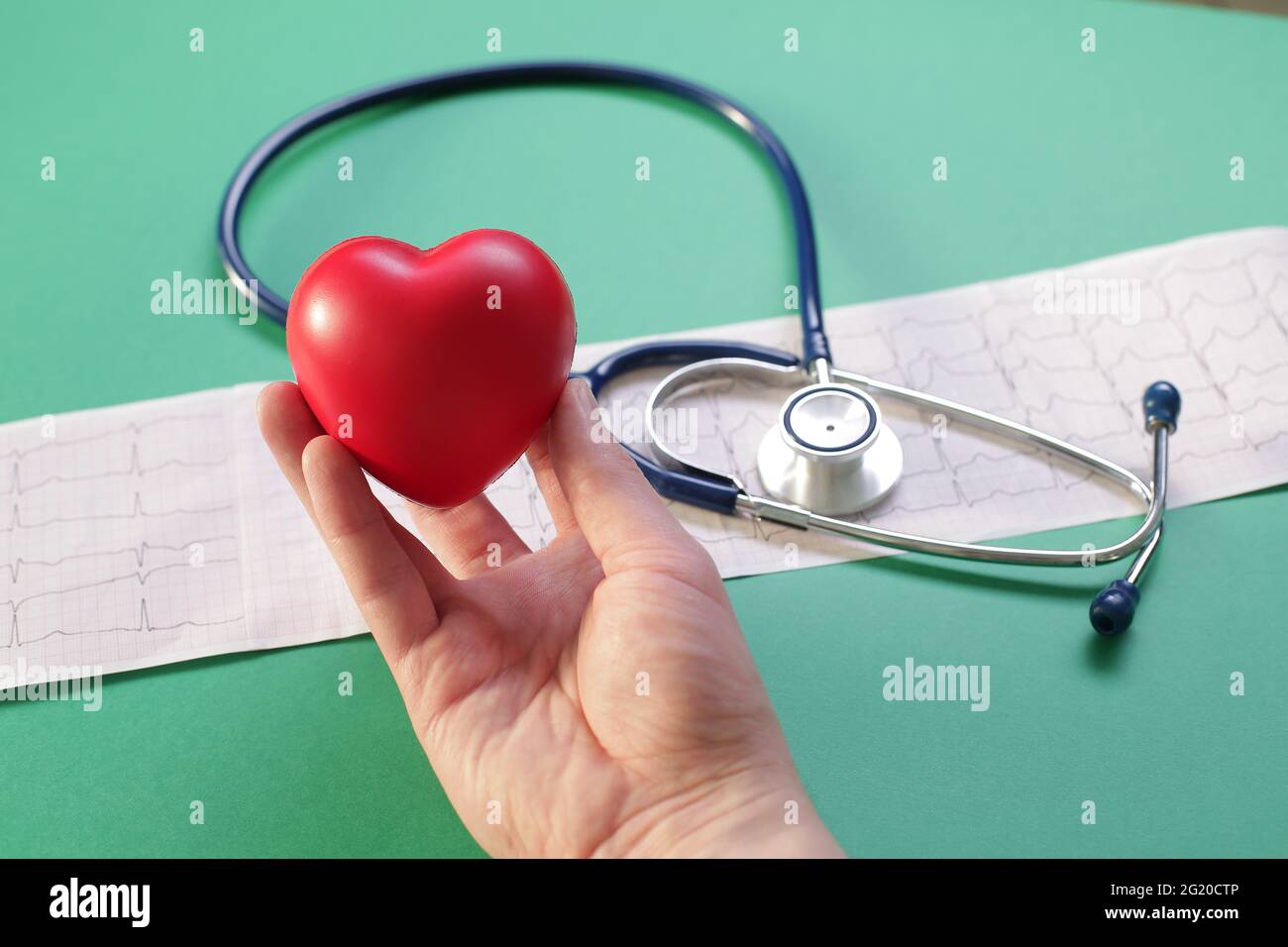 https://c8.alamy.com/comp/2G20CTP/doctors-hand-with-stethoscope-heart-and-cardiogram-on-green-background-2G20CTP.jpg