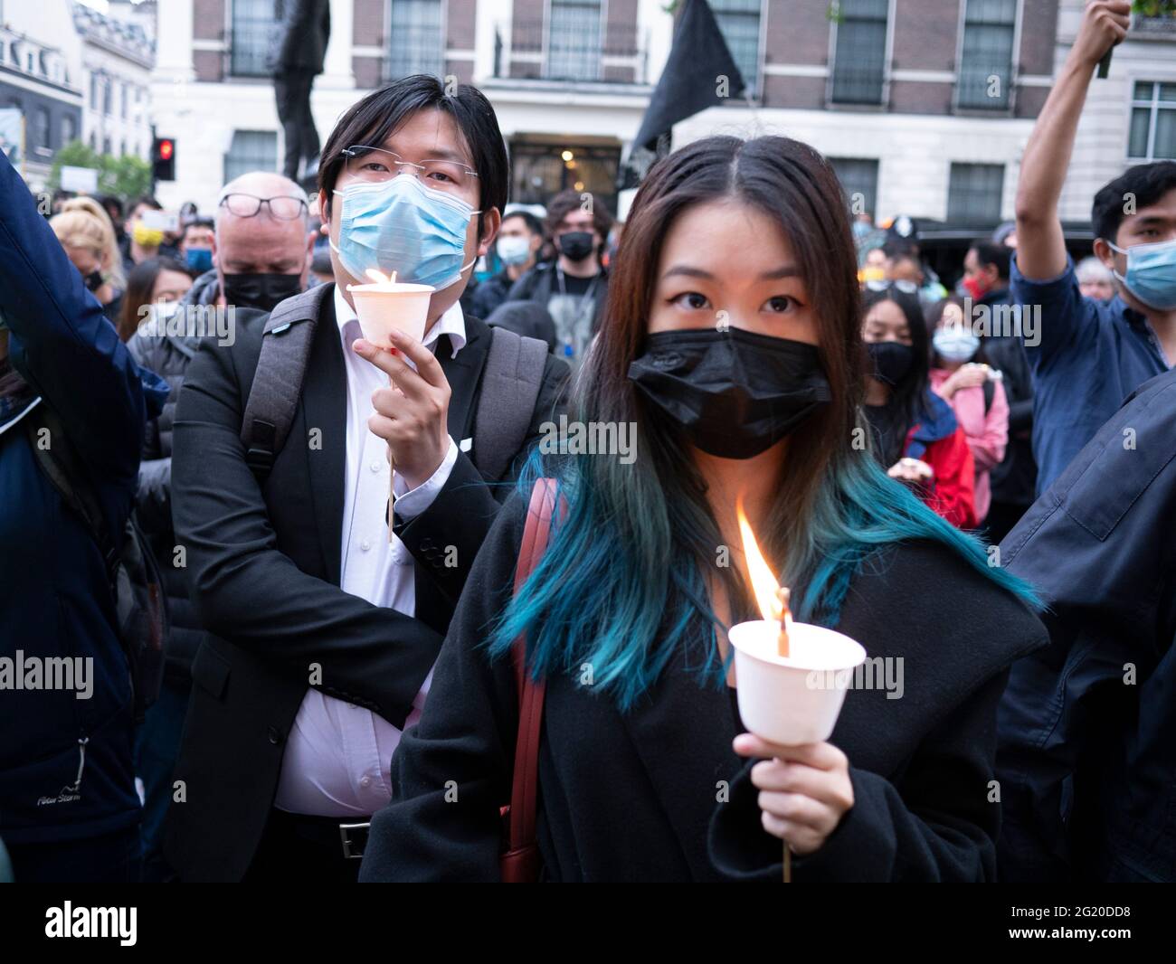 Masked Protesters Rally with candles opposite the  Chinese Embassy in London UK,  marking the 32nd anniversary of the  June 4th massacre at Tiananmen Square, China. Stock Photo