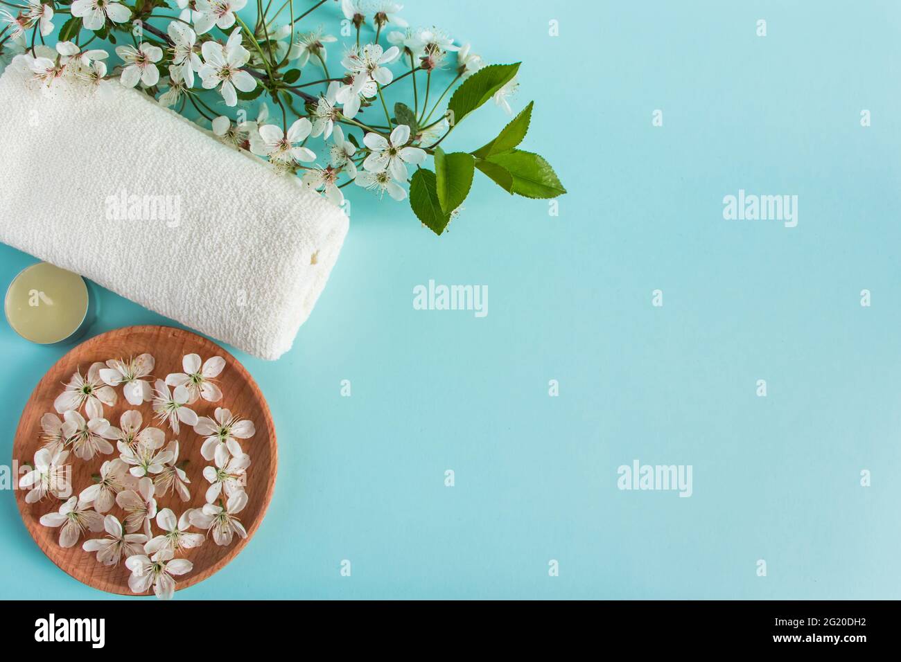 Natural organic beauty products for spa and aromatherapy. Aromatic essential oil, candles and a towel on a blue background. Relaxation concept, place Stock Photo
