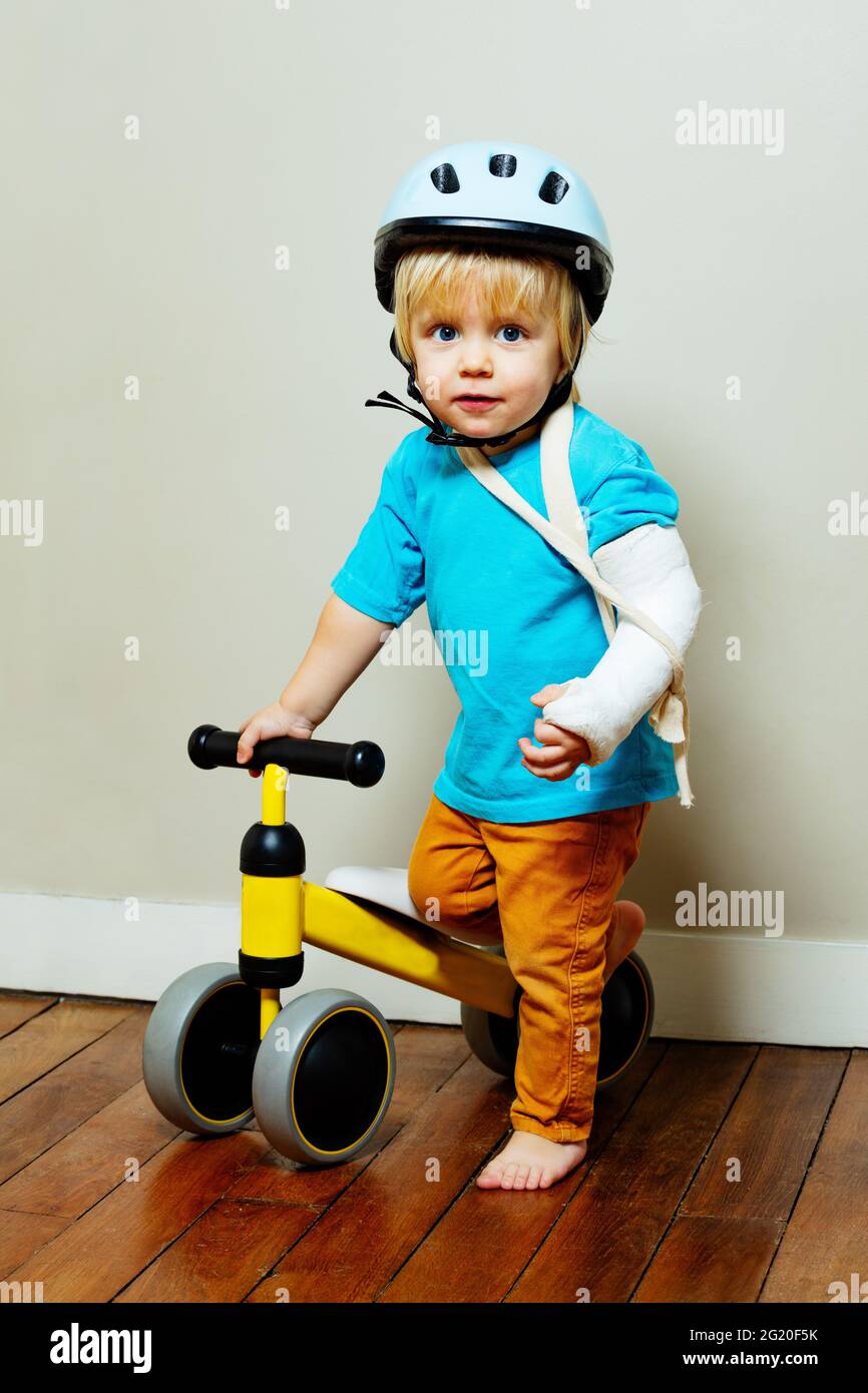 Boy with broken hand in plaster and little bicycle Stock Photo