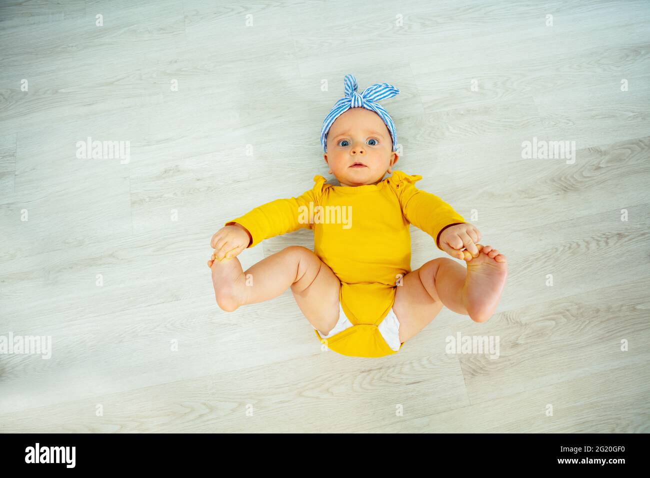 Little baby girl with blue bow view from above Stock Photo
