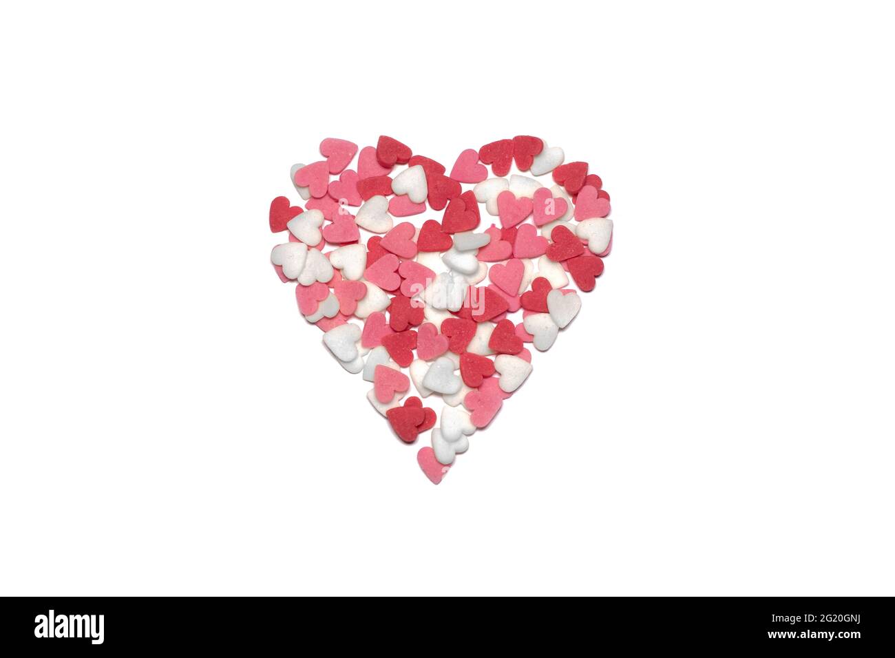 Sweet hearts. Pink, red and white heart shaped sugar sprinkles. Colorful heart made of lots of little hearts. Valentines day or Mothers day background Stock Photo