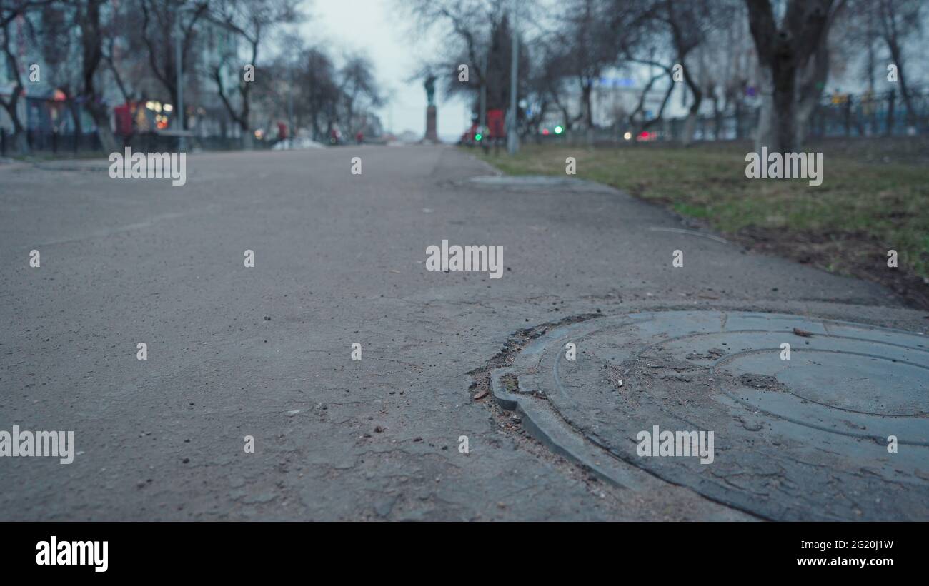 Photo of dismal alley with manhole during early spring Stock Photo