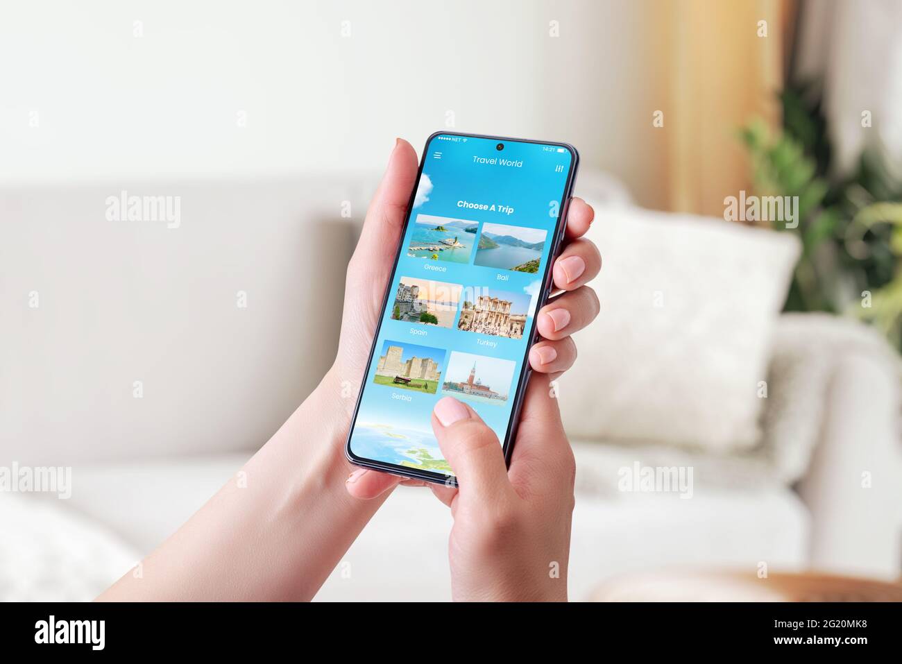 Choosing a travel destination with smart phone concept. Modern app with chose a trip option. Phone in woman hand. Close-up. Stock Photo