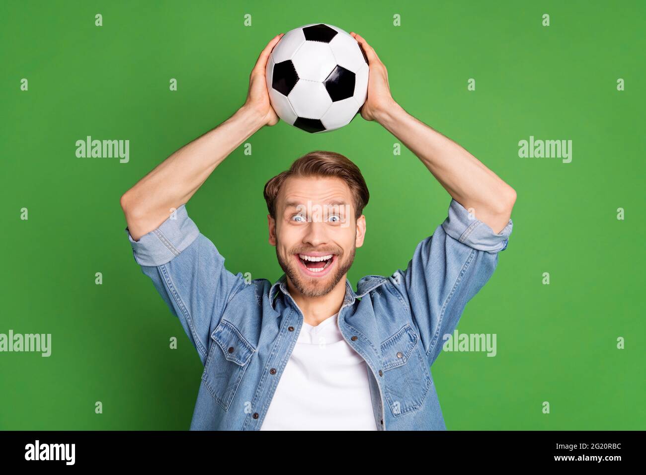 Photo portrait of football fan keeping soccer ball smiling amazed