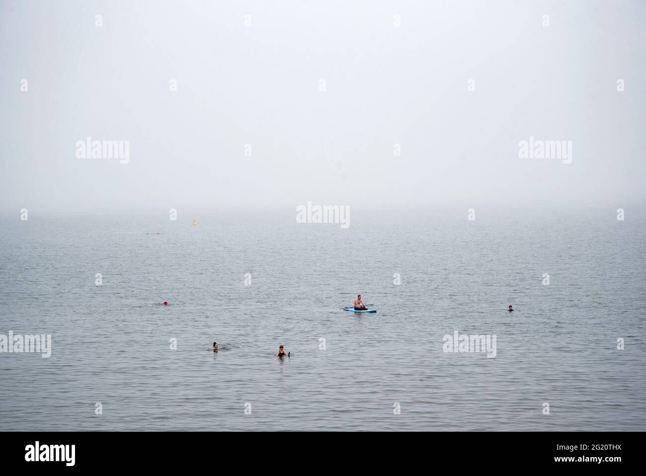 Wild swimming in the haar or sea fog at Wardie Bay on the Firth of Forth, Edinburgh, Scotland, UK. Stock Photo