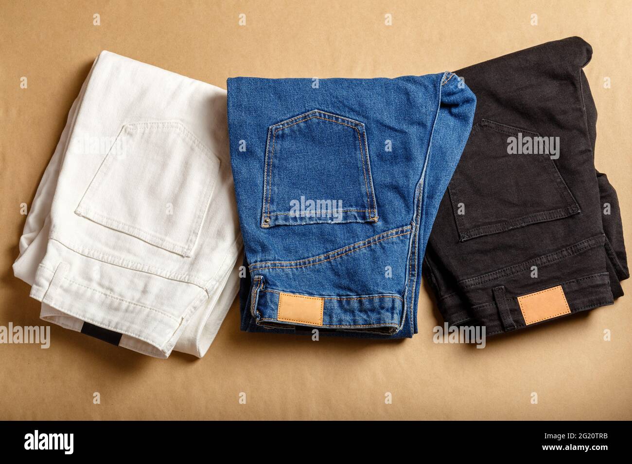 White blue black jeans pants stacked. Assortment of different color denim  clothing in store shop. White denim jean pants, blue jeans, black denim.  Top Stock Photo - Alamy