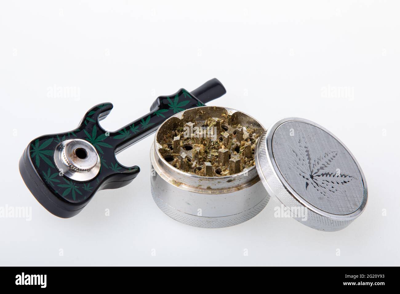 Cannabis pipe with hemp leaves drawings on it and a grinder with cannabis  in it Stock Photo - Alamy