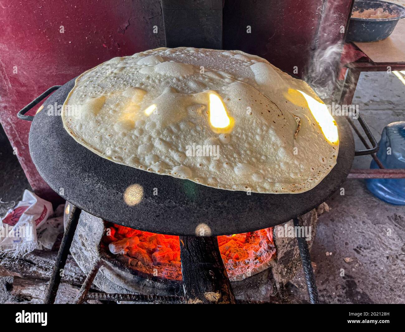 Flour tortillas cooked on a steel comal with the fire of the mesquite
