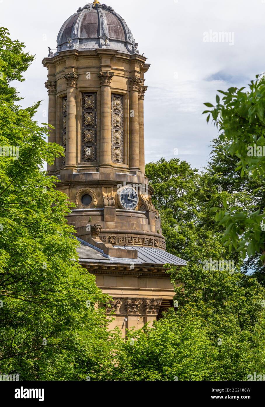The tower of Saltaire United Reformed Church seen through trees in West Yorkshire. The Victorian church was built by Sir Titus Salt. Stock Photo