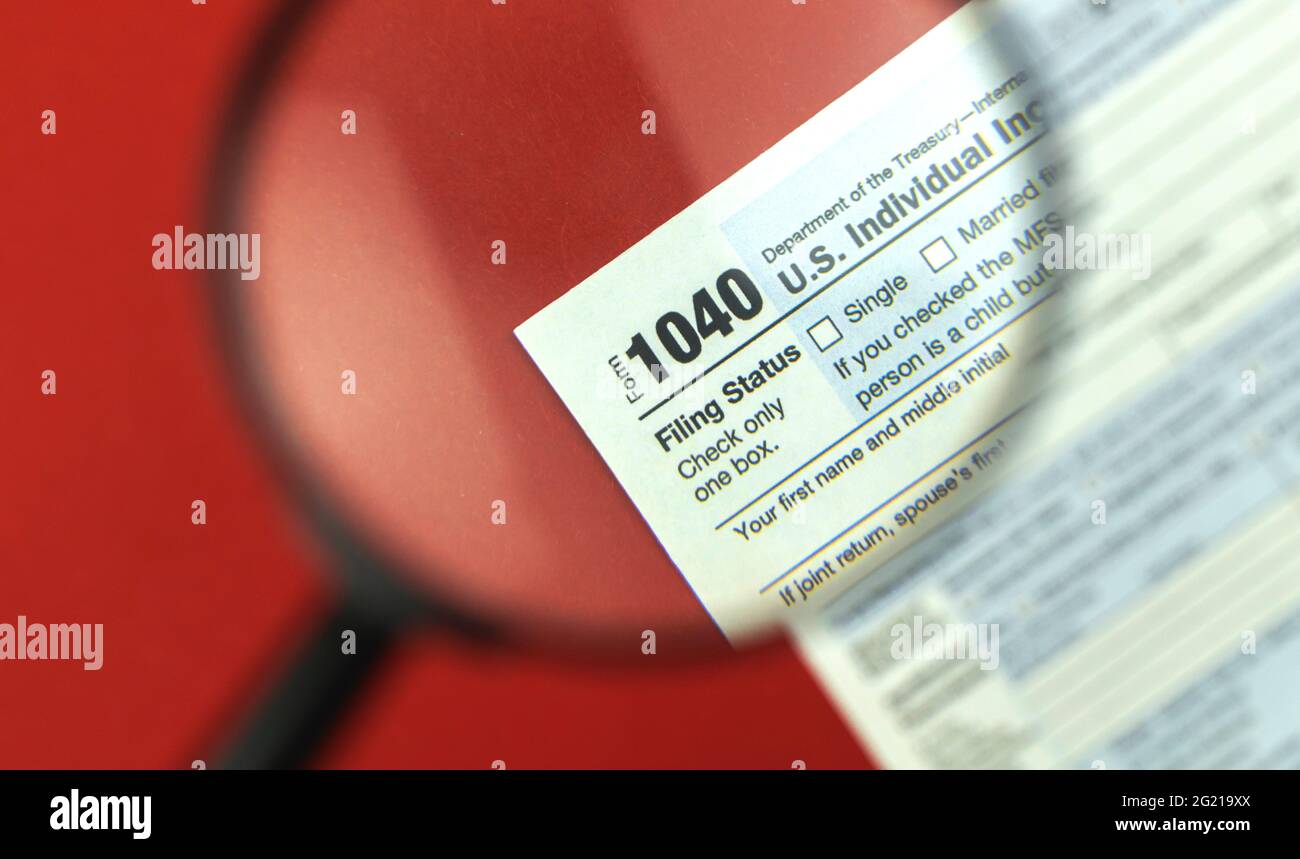 Tax season with magnifying glass, 1040 tax form background, red office ...