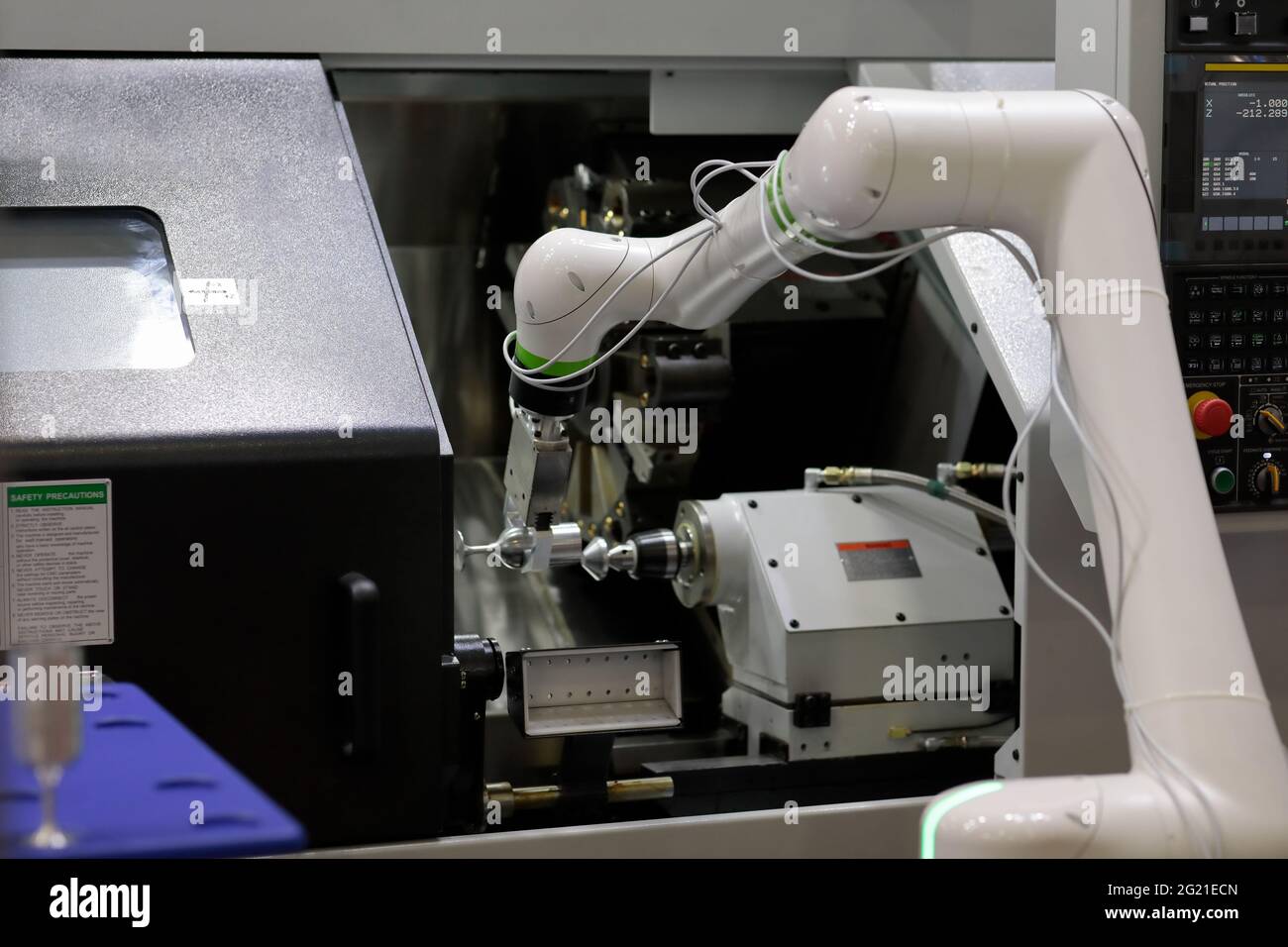 CNC lathe machine and collaborative robot loading the workpiece Stock Photo