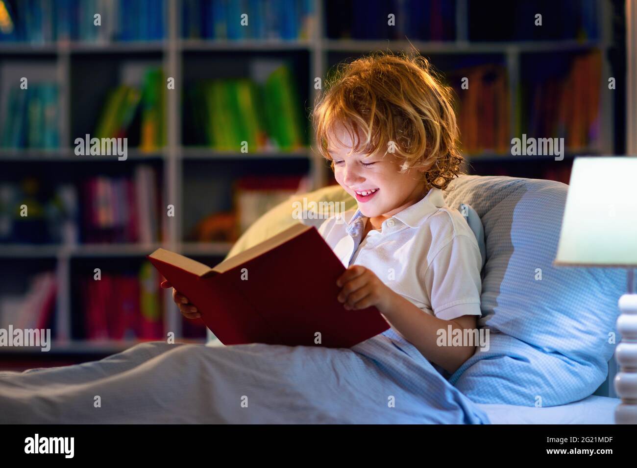 Child reading book in bed. Kids read at night. Little boy with fairy tale  books in bedroom . Education for young children. Bedtime story Stock Photo  - Alamy