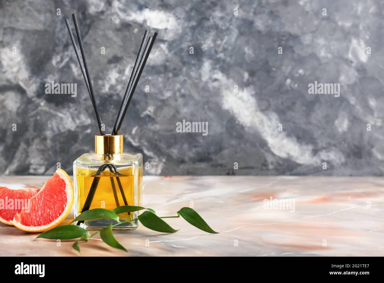 Reed diffuser with grapefruit on grunge background Stock Photo