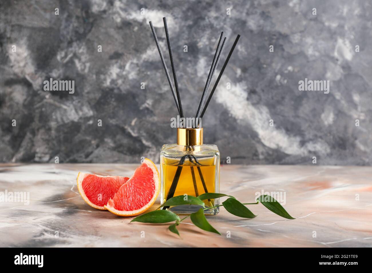 Reed diffuser with grapefruit on grunge background Stock Photo