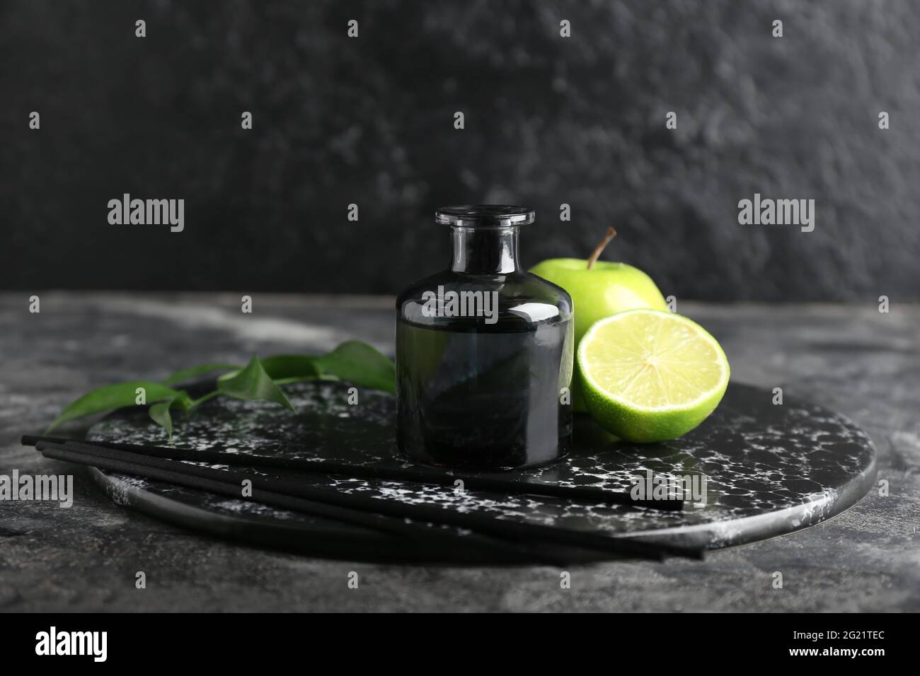 Reed diffuser with fruits on dark background Stock Photo - Alamy