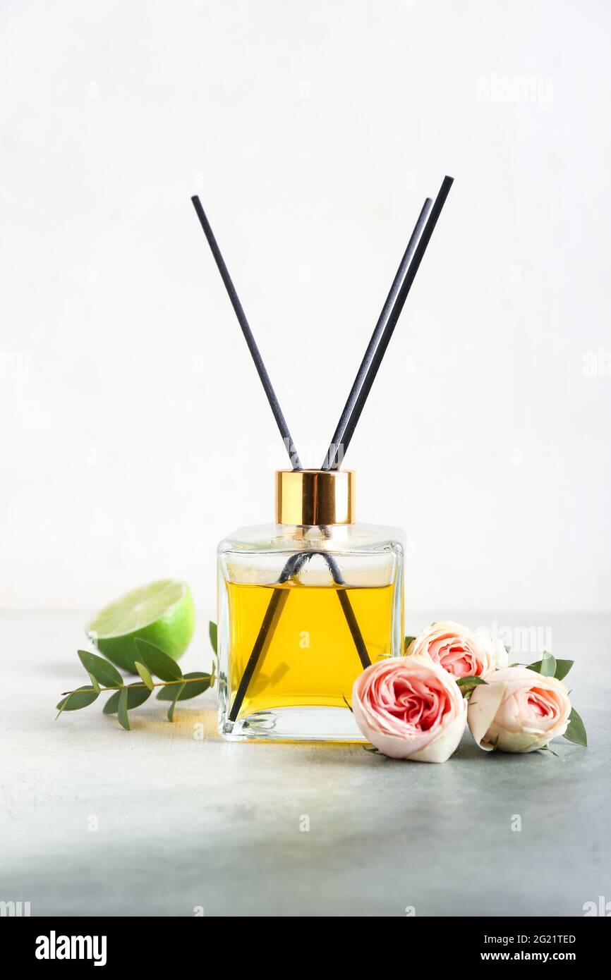 Reed diffuser with roses and lime on light background Stock Photo