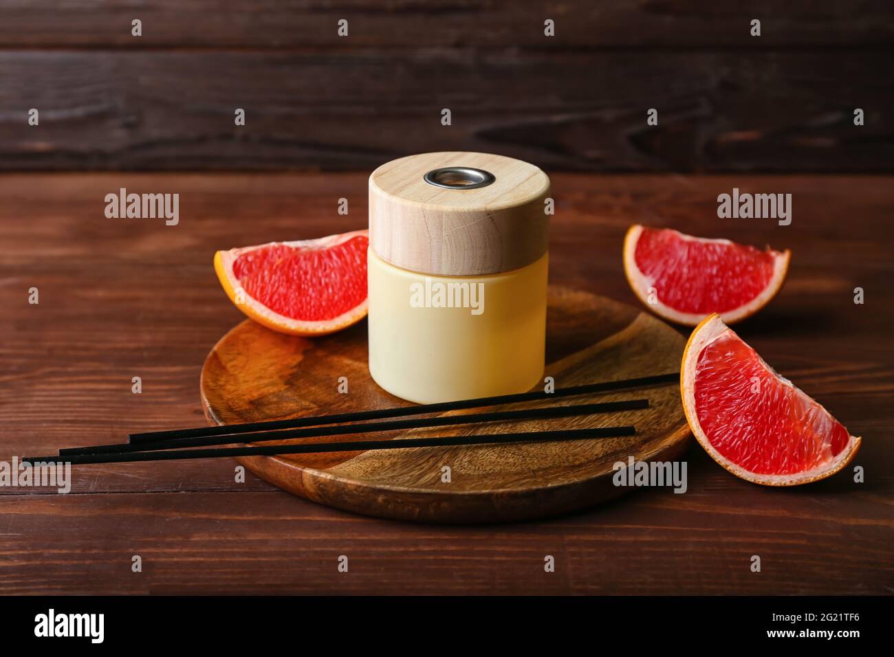 Reed diffuser with grapefruit on wooden table Stock Photo
