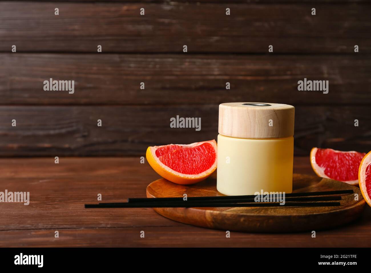 Reed diffuser with grapefruit on wooden table Stock Photo