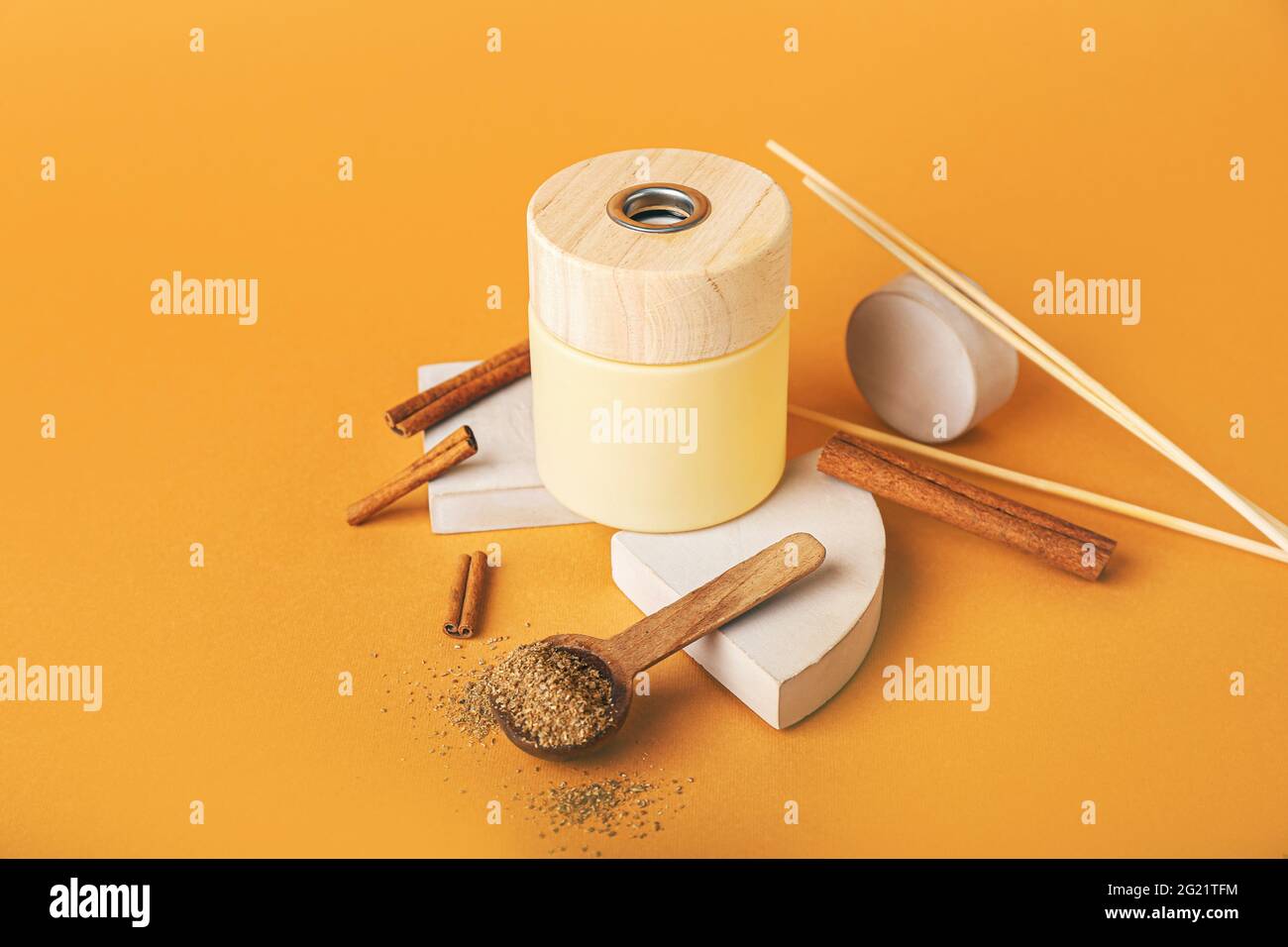 Reed diffuser with cinnamon on color background Stock Photo
