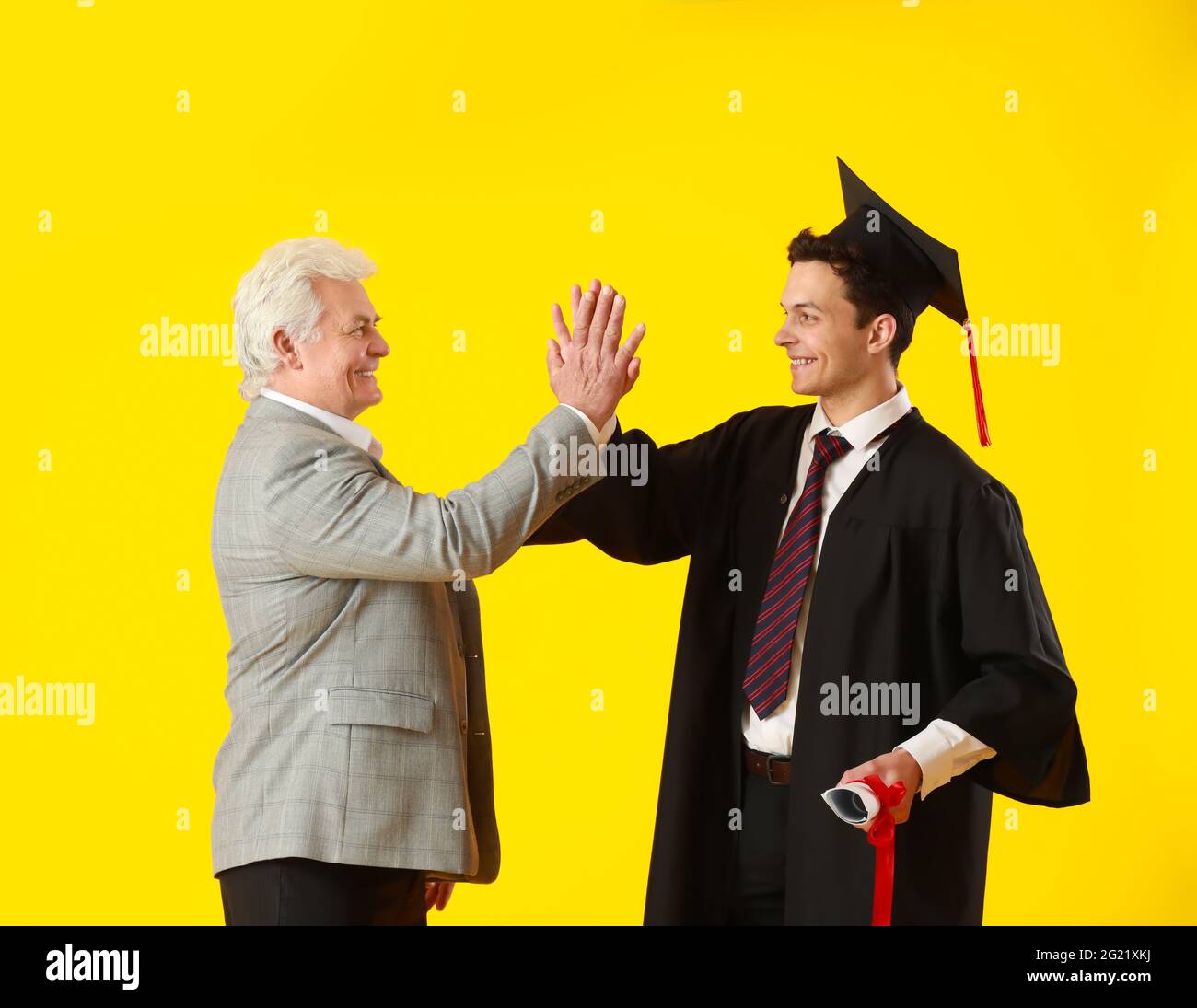 Happy male graduation student with his father on color background Stock ...