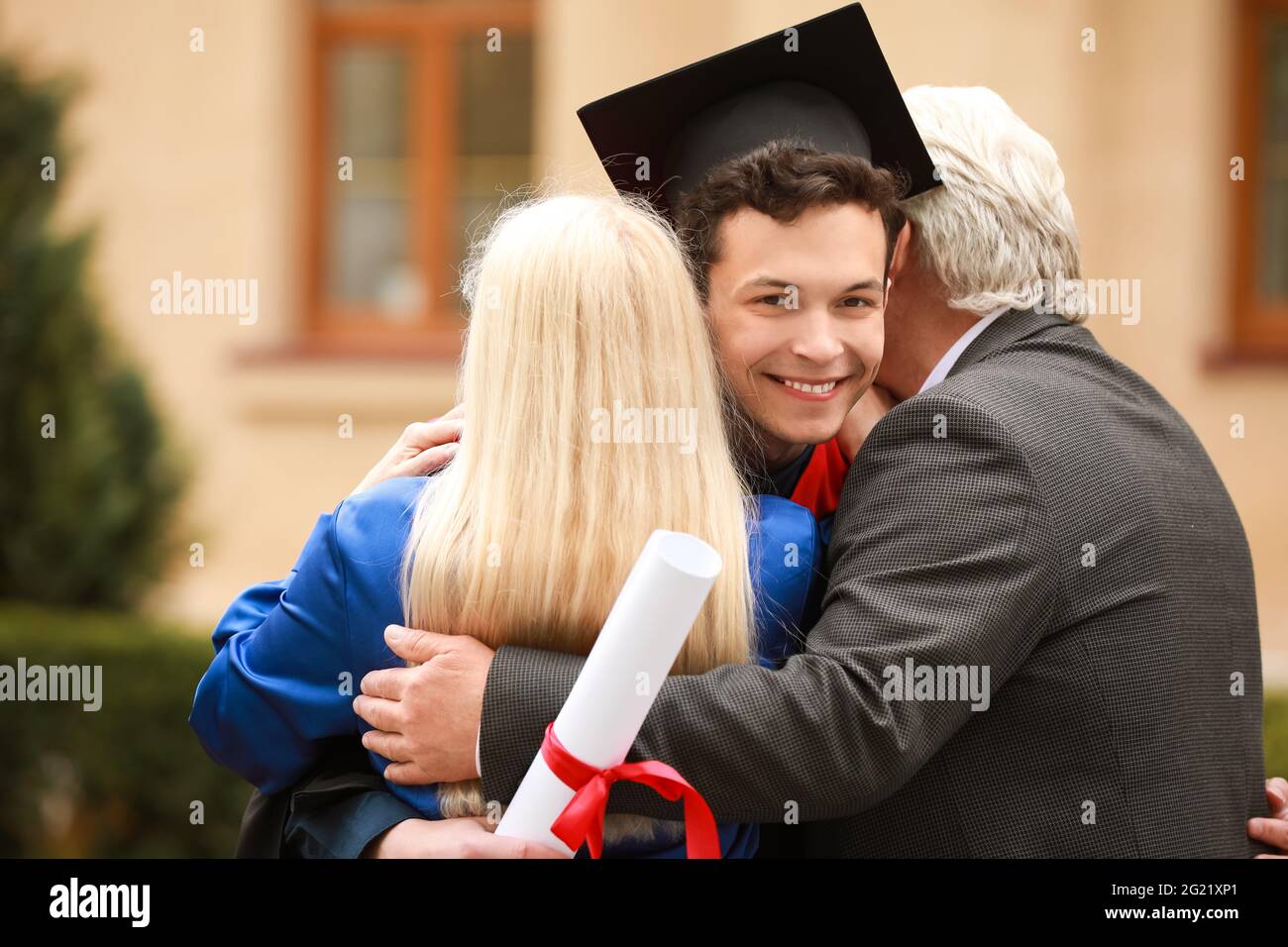 Happy young man with his parents on graduation day Stock Photo - Alamy