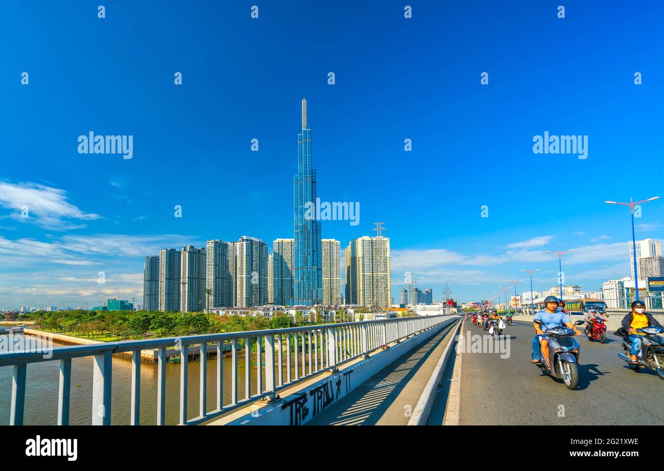 Traffic on the bridge next to the riverside high-rise urban area ...