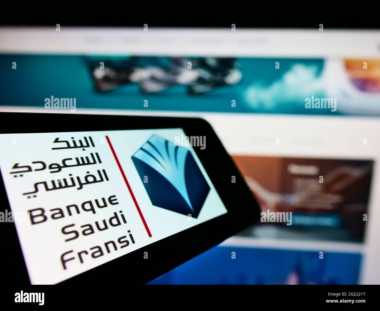 Cellphone with logo of Saudi Arabian bank Banque Saudi Fransi (BSF) on screen in front of business website. Focus on center of phone display. Stock Photo