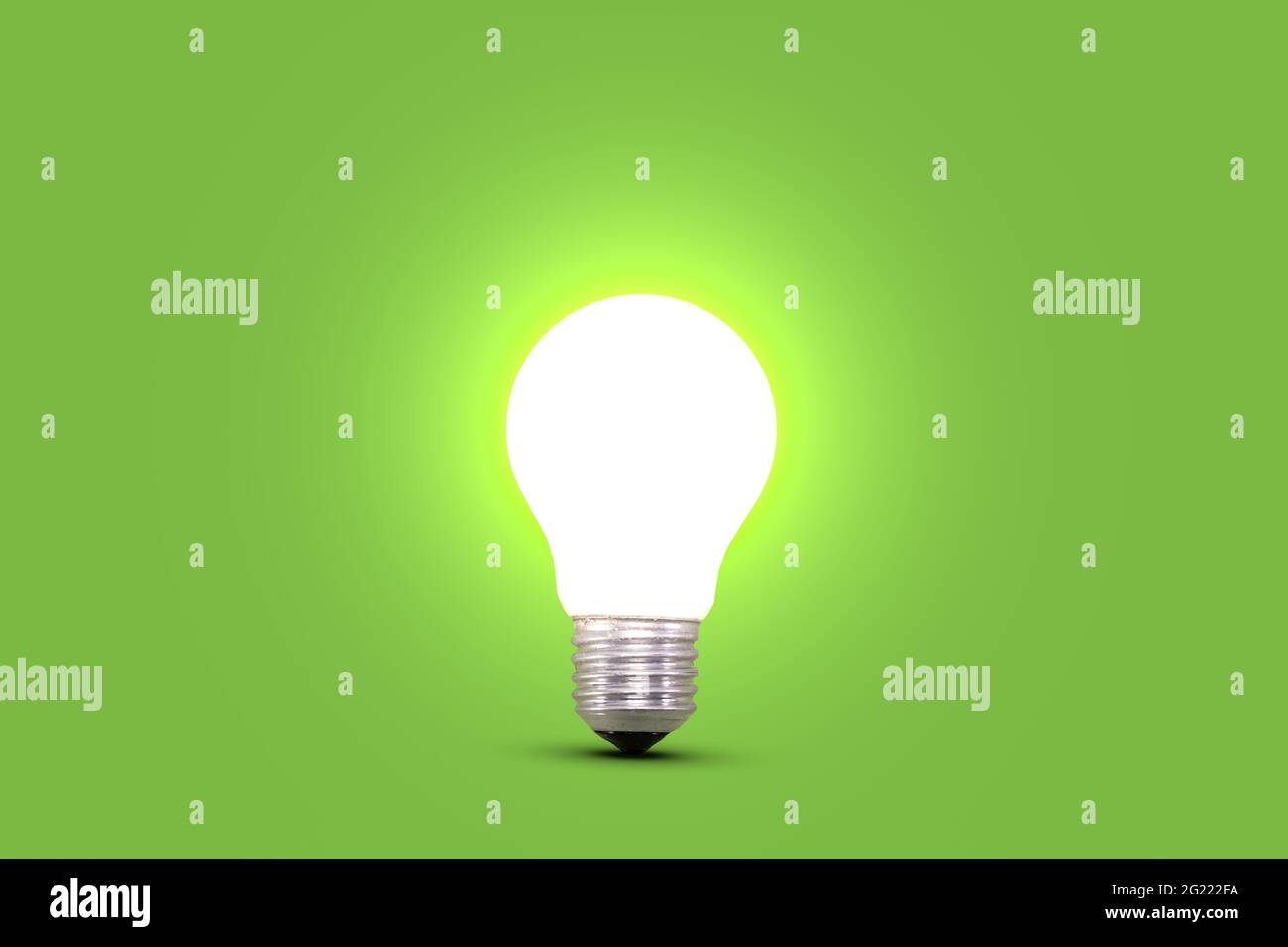 Glowing light bulb isolated on green background. Idea and innovation concept. Stock Photo
