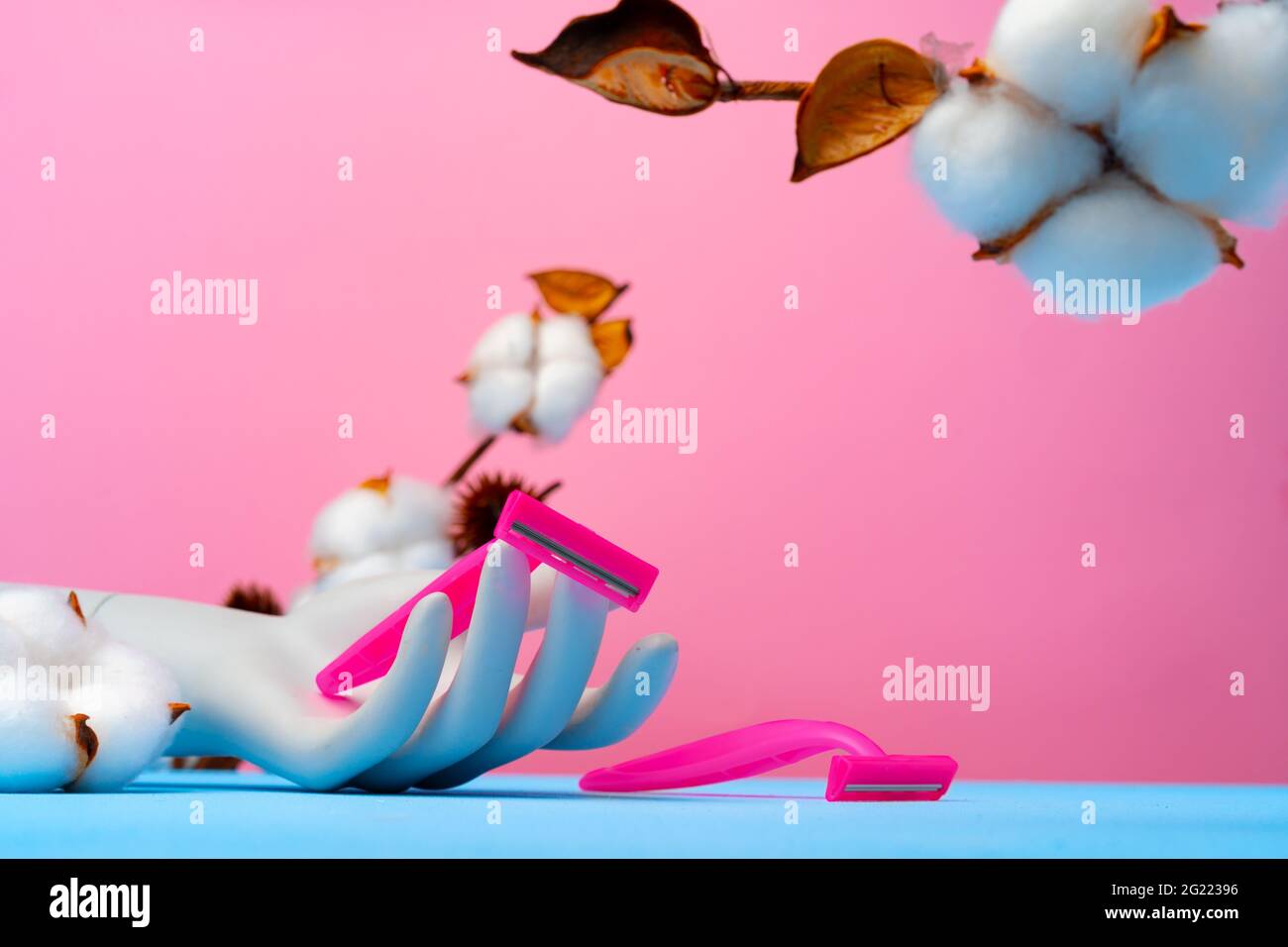 Pink disposable razors and cotton flower on blue paper Stock Photo - Alamy