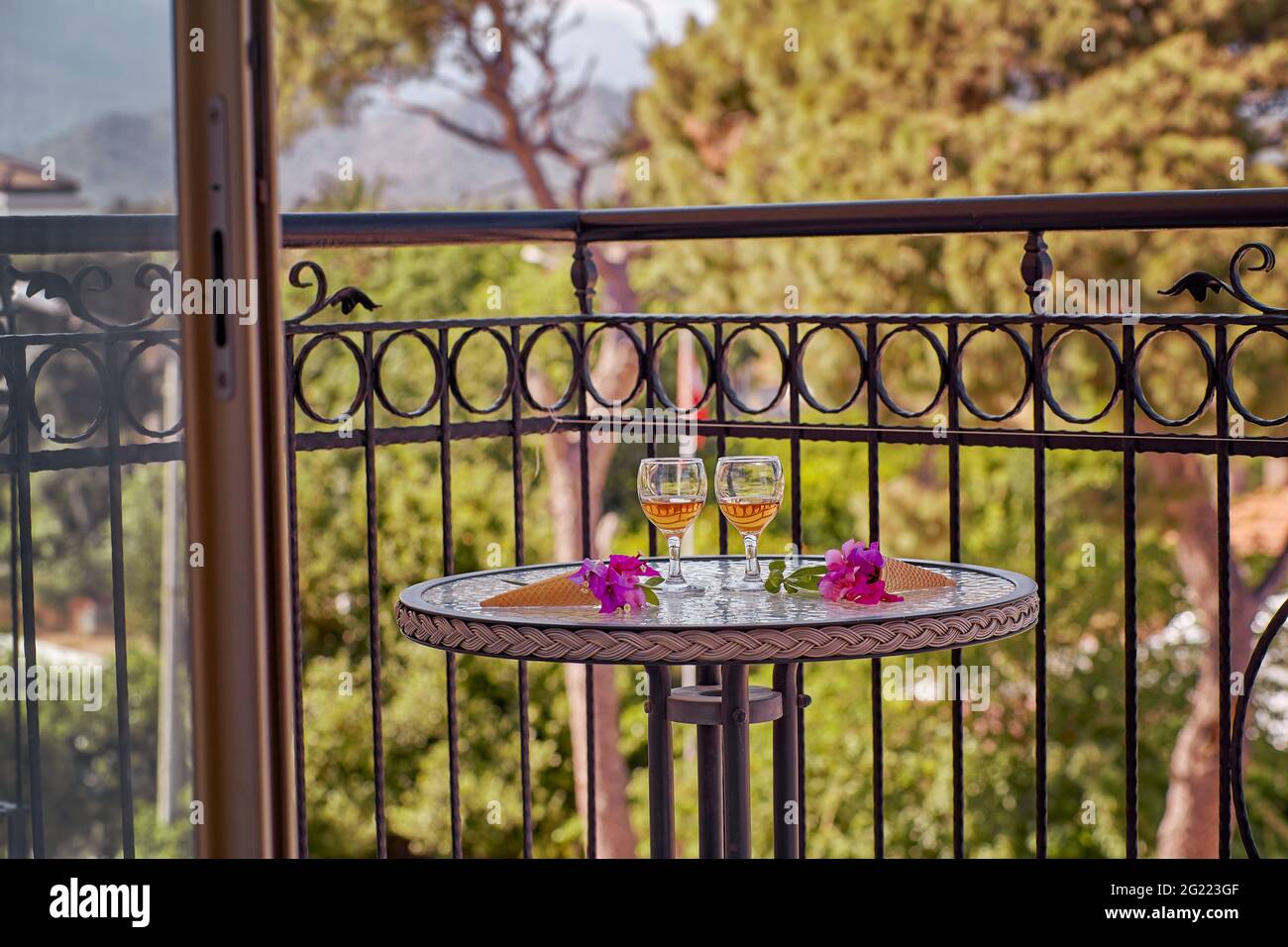 Relaxing summer cocktails and surreal flowers of bougainvillea in front of Turkey flag, mountains and trees. Travel Turkey concept. Romantic morning at the balcony. Stock Photo