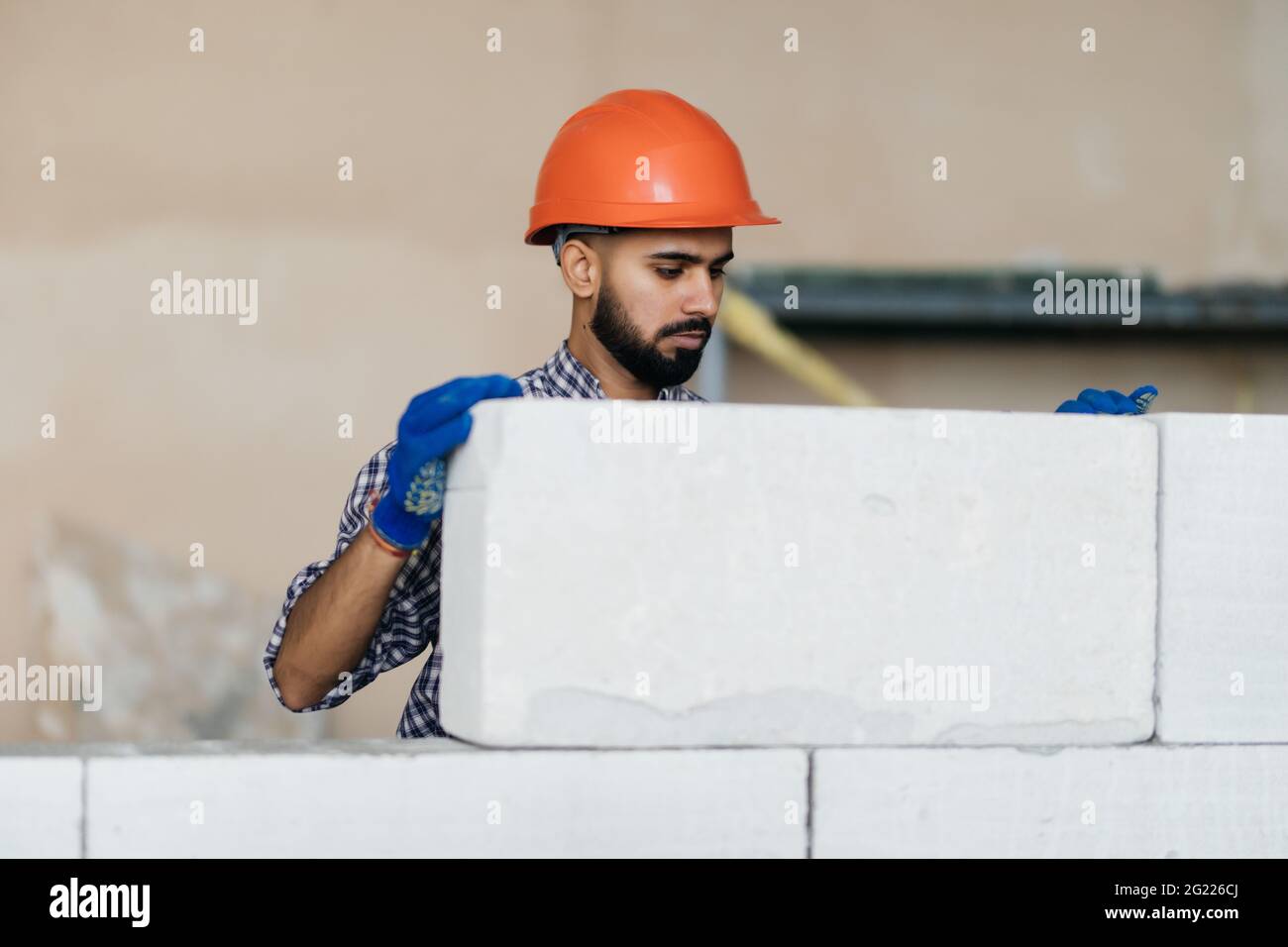 bricklayer builder working with autoclaved aerated concrete blocks