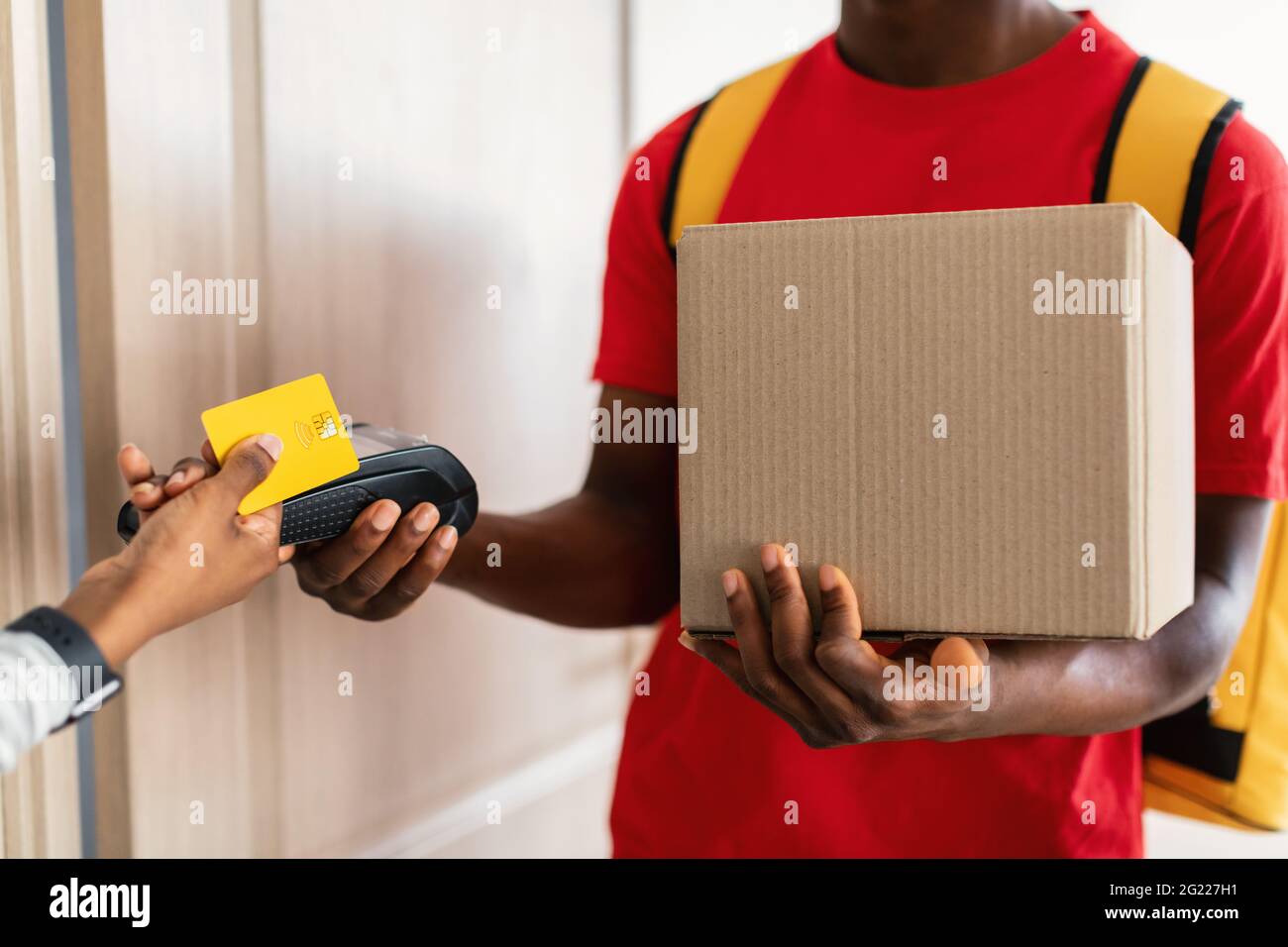 Customer Paying Courier For Parcel Delivery With Credit Card Indoor Stock Photo