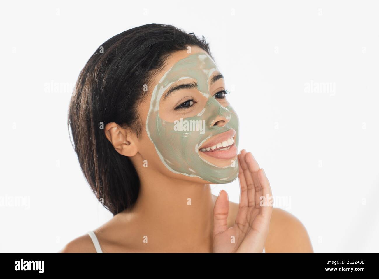 happy young african american woman with mud mask on face looking away