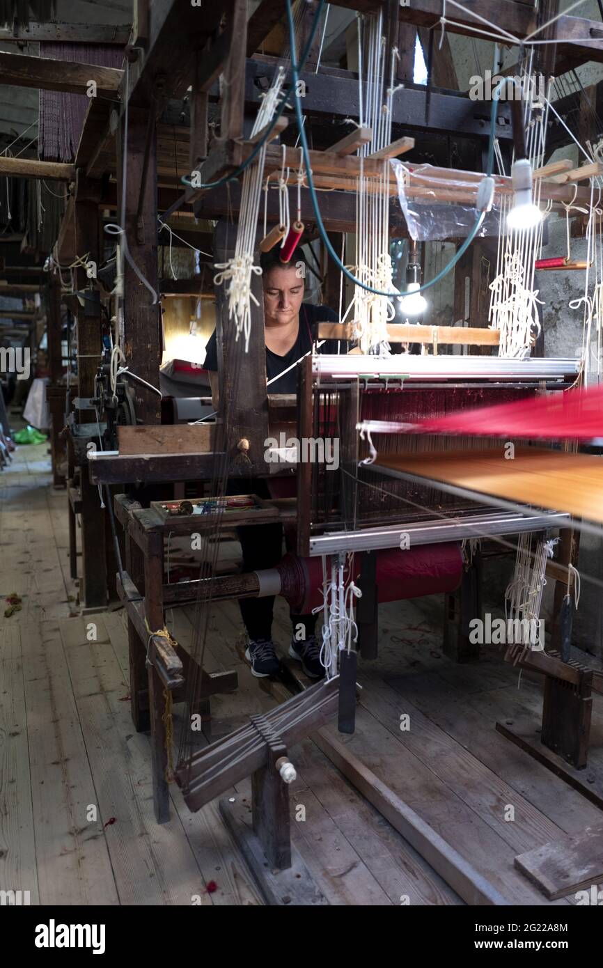 A female worker at the historical handcrafted weaving Luigi Bevilacqua, they produce fine fabrics for furniture and high fashion, in Venice, Italy Stock Photo