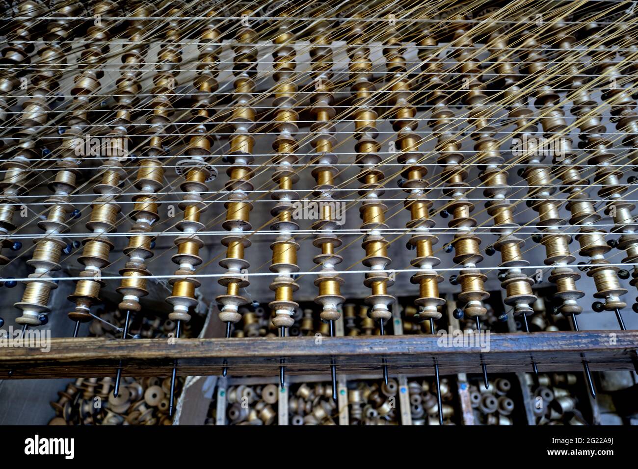 Golden thread fuzes on a traditional wooden looms of the Bevilacqua weavers, produce luxury textile in Venice since 1875. Stock Photo