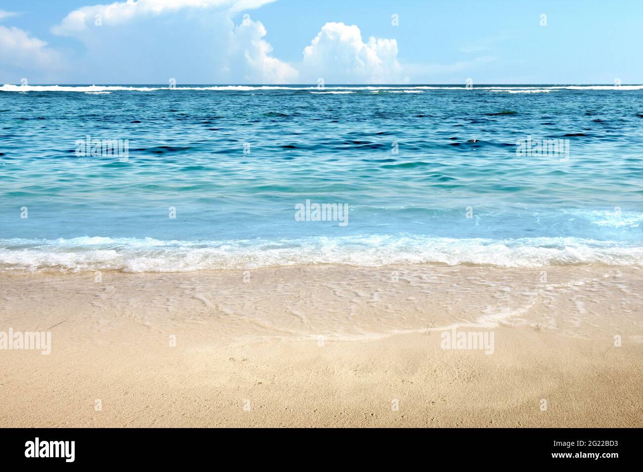 Sandy beach with the blue ocean and blue sky background Stock Photo - Alamy
