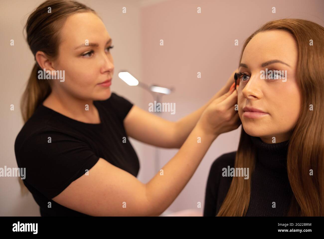 Female Specialist Using Mascara On Customer's False Eyelashes Stock Photo