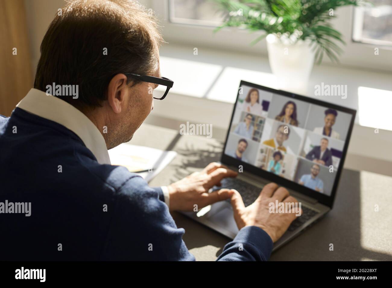 Senior man having virtual business meeting with team of employees and colleagues Stock Photo