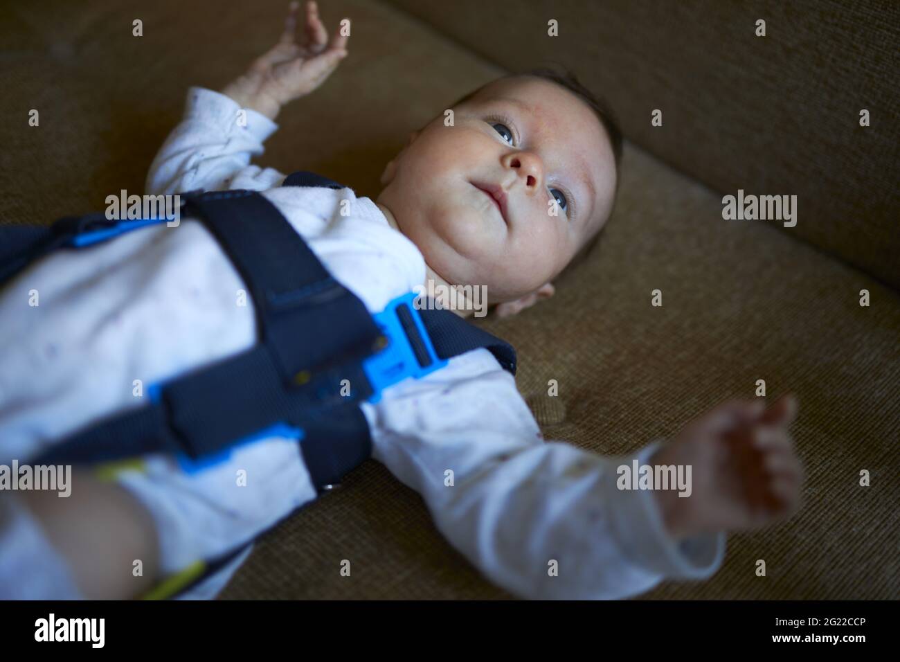 Baby laying on the back wearing Pavlik harness Stock Photo