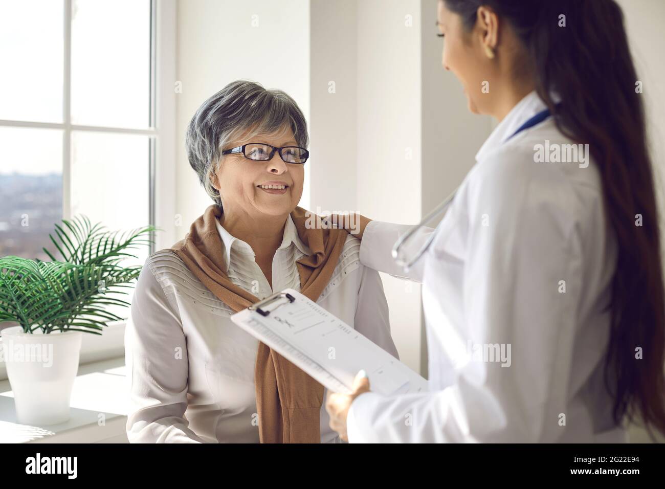Senior woman looking at doctor and listening to her advice with happy smile on face Stock Photo
