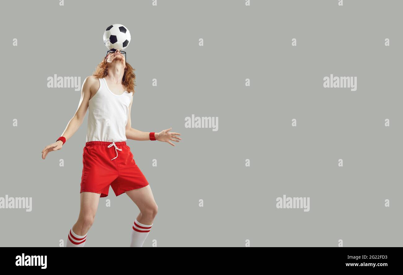 Skinny man balancing a football on his forehead isolated on a copy space background Stock Photo