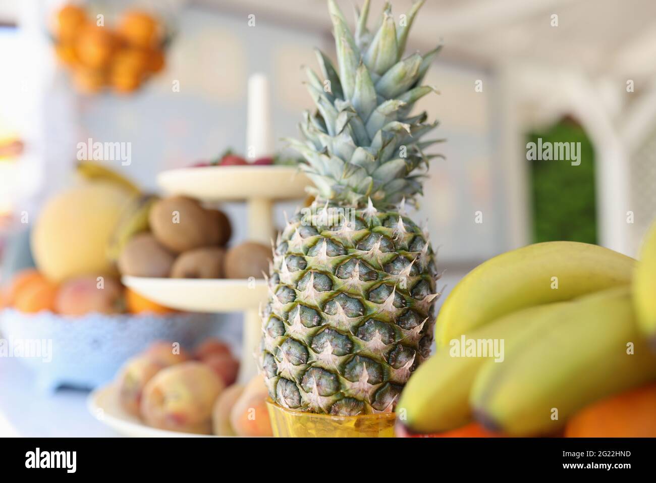 Pineapple bananas and other fruits are on plate Stock Photo Alamy