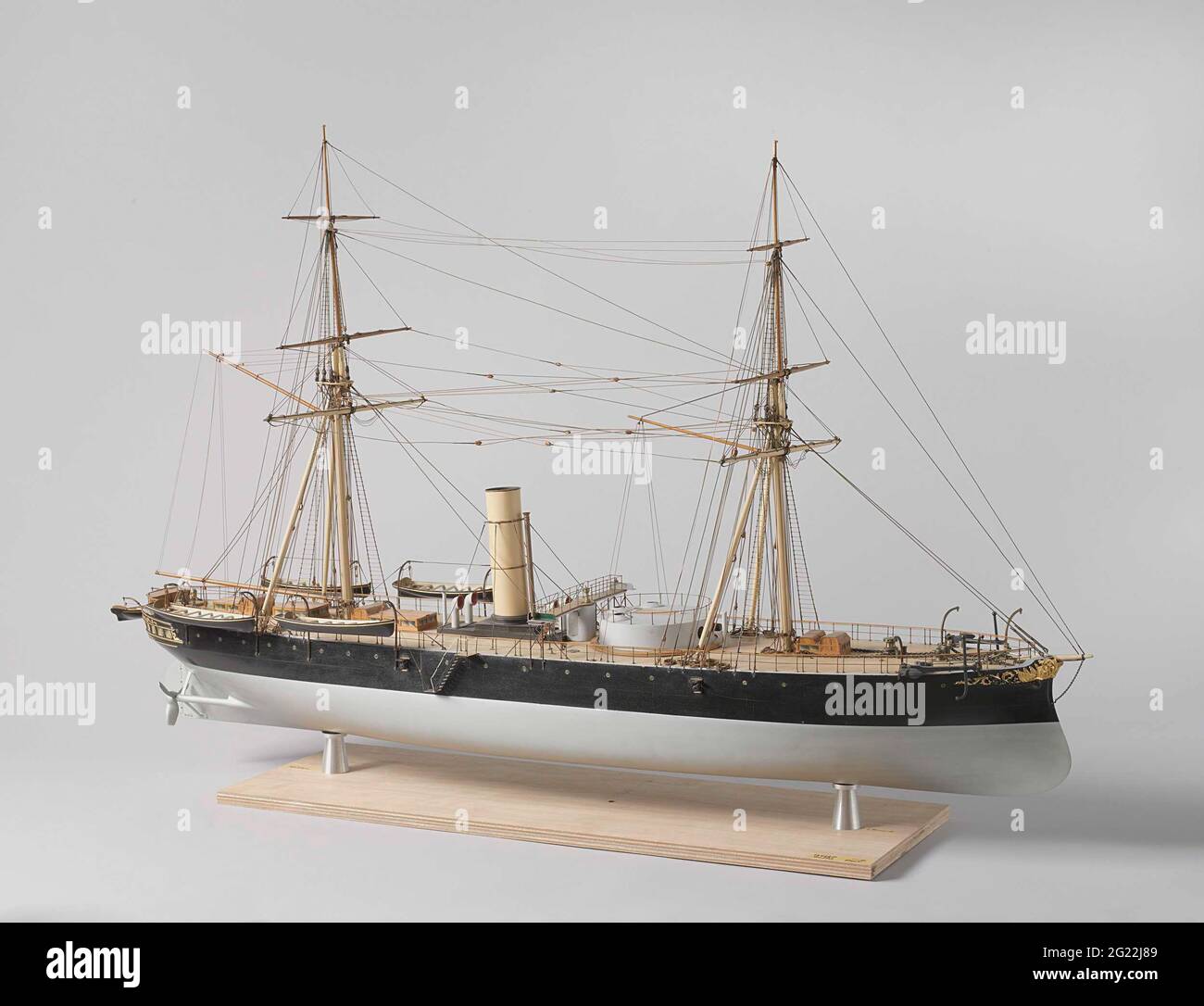 Model of An IronClad Ram Ship. Polychromed and witnessed block model of a ram tower vessel, the base board is missing. It has the government arms on the mirror and gold-plated carving. The model has a flat deck; It has a ramsteven, round steering, stir with rounded leaves, and two double-leaf screws. The steering wheel stands entirely on the main deck; No build-up are built on the deck, apart from a few roasts and strips, the gunpost with two cannons and a bridge between the dome and the chimney. The railing is double for cage beverage. The model has five sloops in Davits. The seam is complete Stock Photo