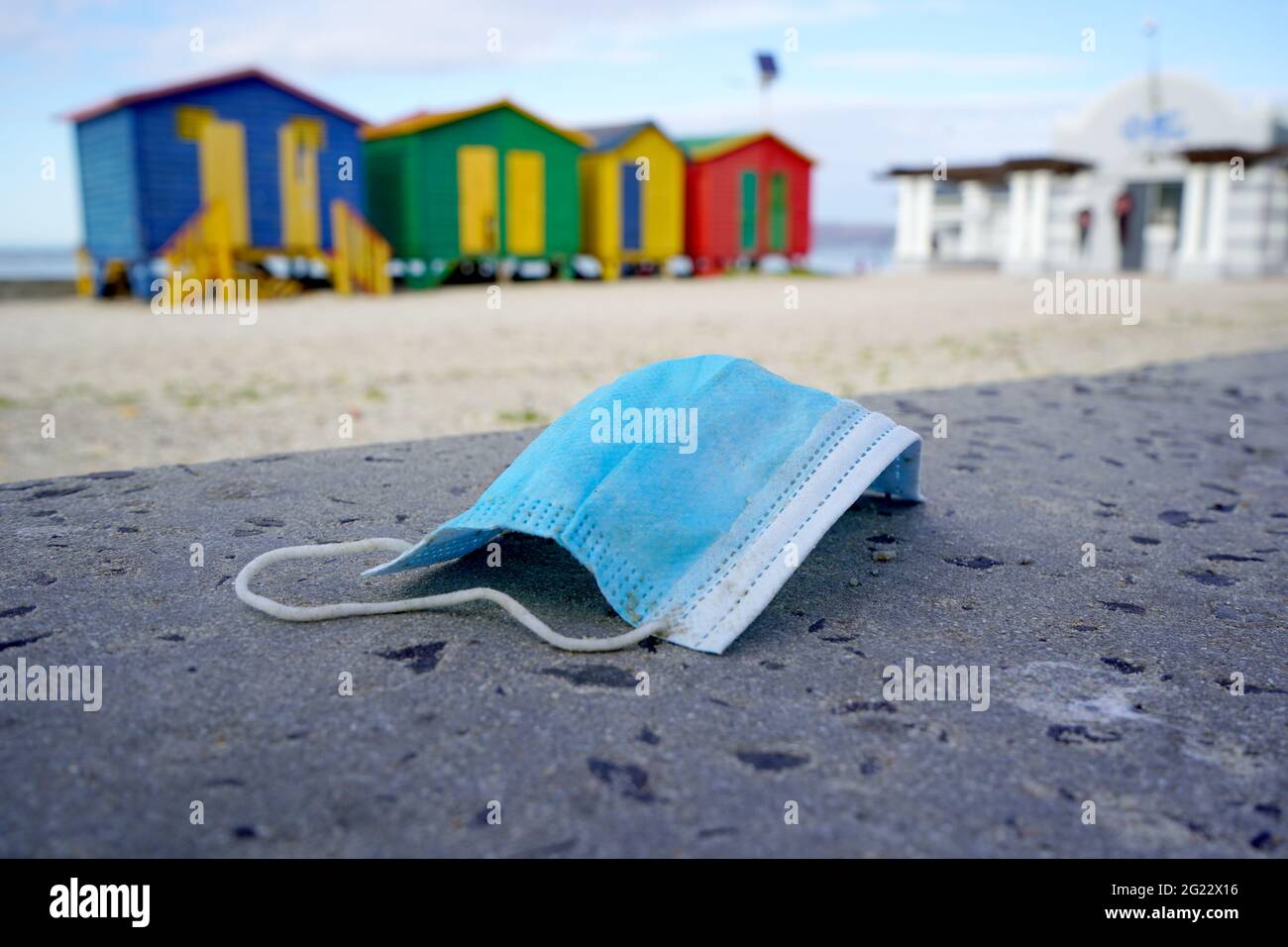 Old used medical mask polluting the beach Stock Photo