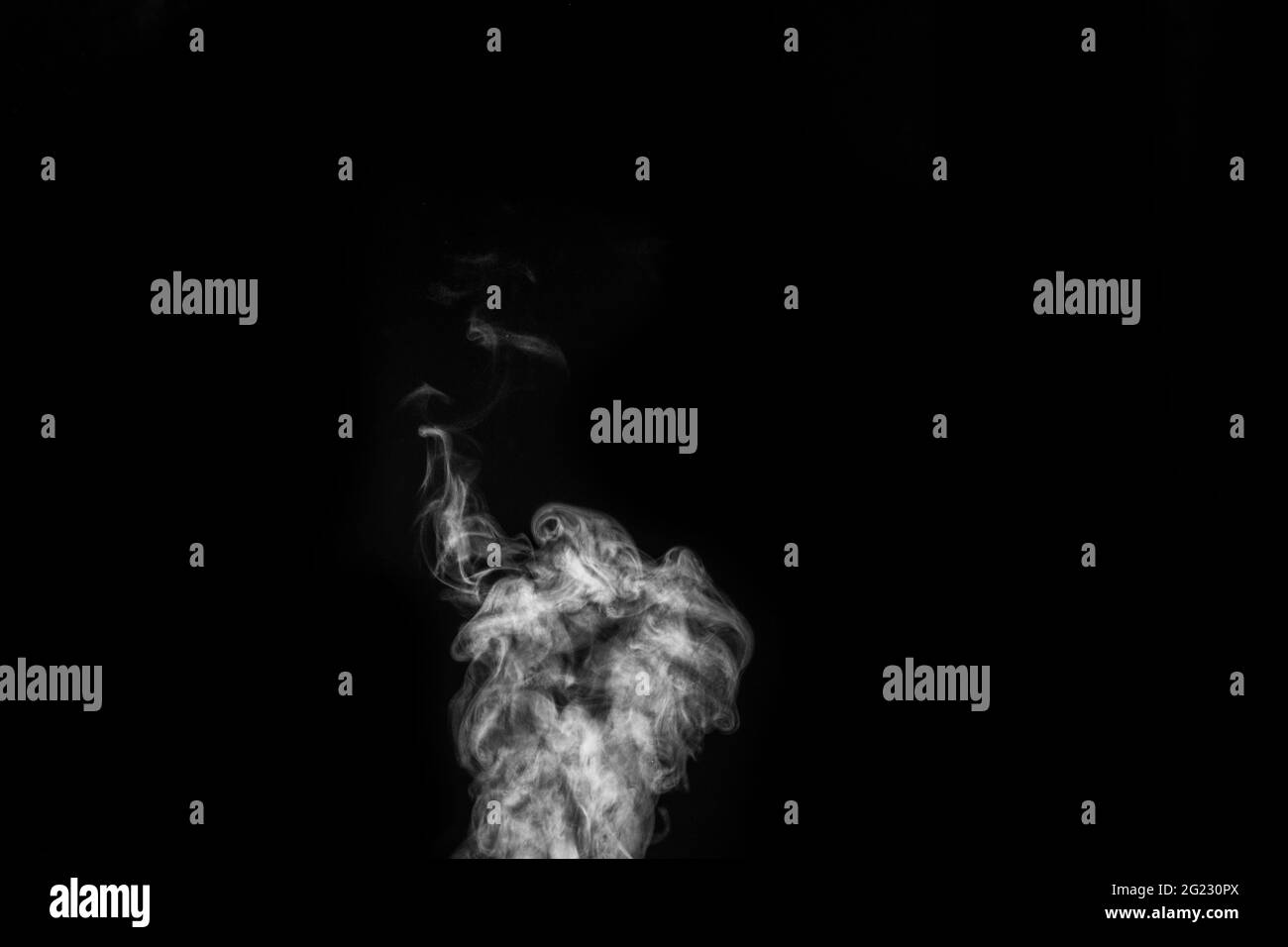 Perfect mystical curly white steam or smoke isolated on black background. Abstract background fog or smog, design element, layout for collages. Stock Photo