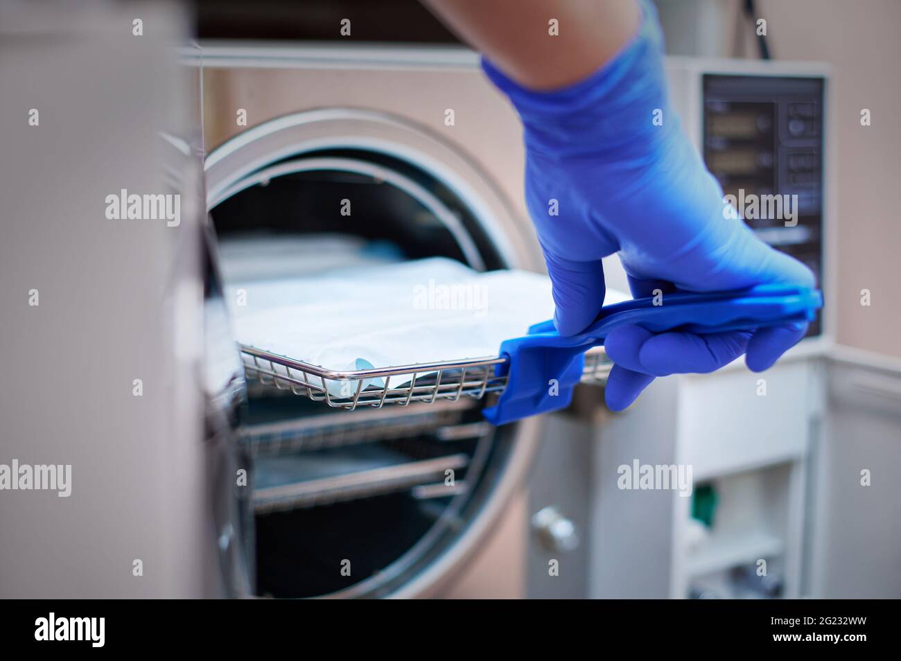 Dentist in blue latex gloves is taking a sealed dental stainless steel