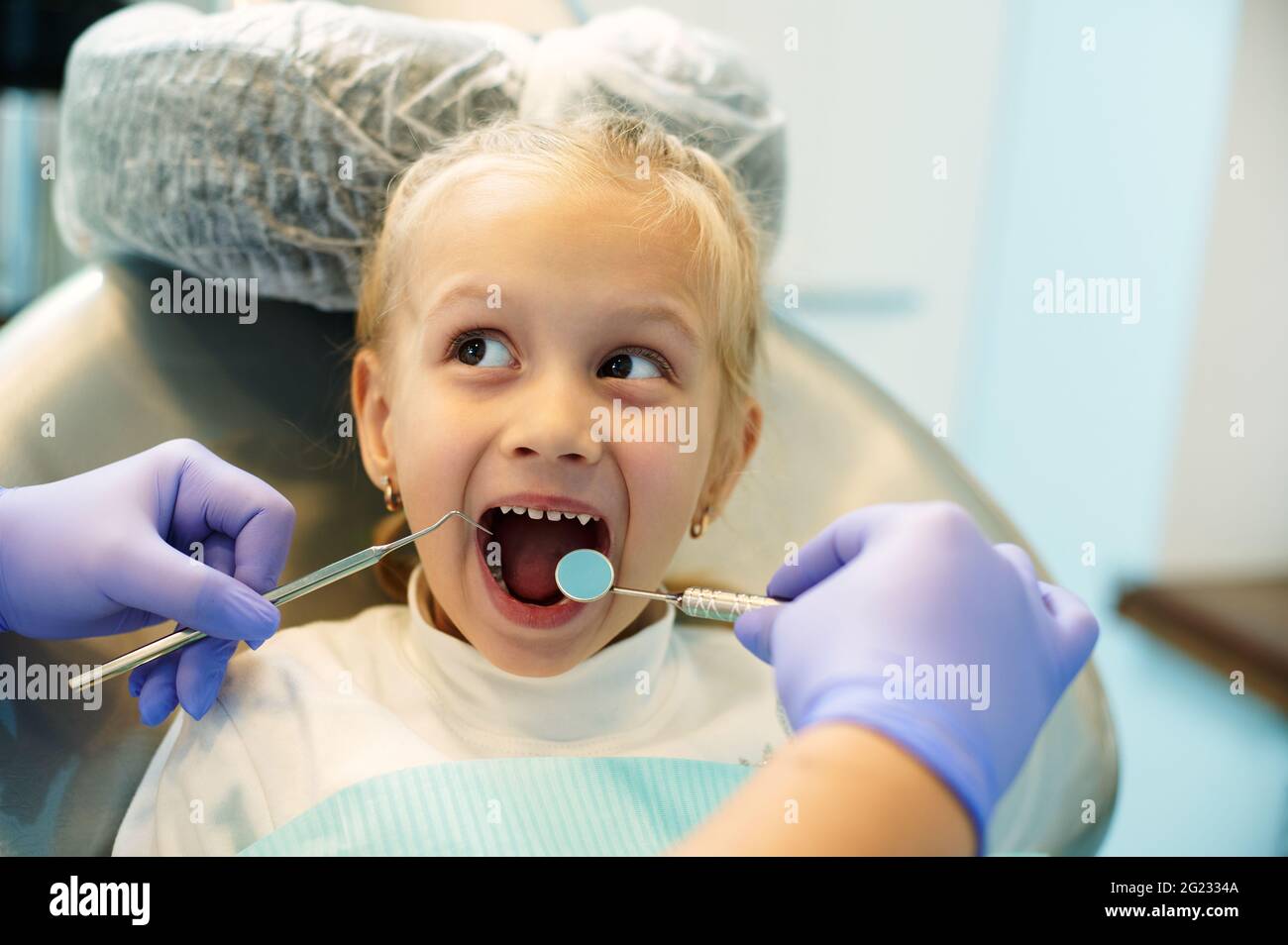 Adorable child with open mouth on examination at the dentist. The