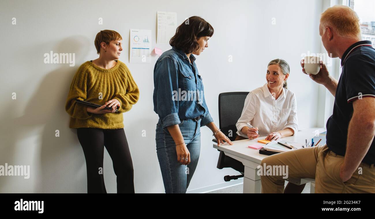 Colleagues talking and working together in office. Creative team discussing new project. Stock Photo